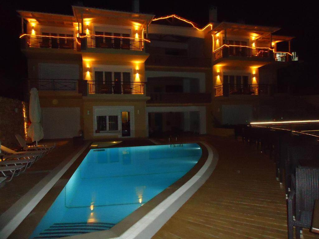 LímniAgrabeli Apartments的一座游泳池,在晚上在建筑物前