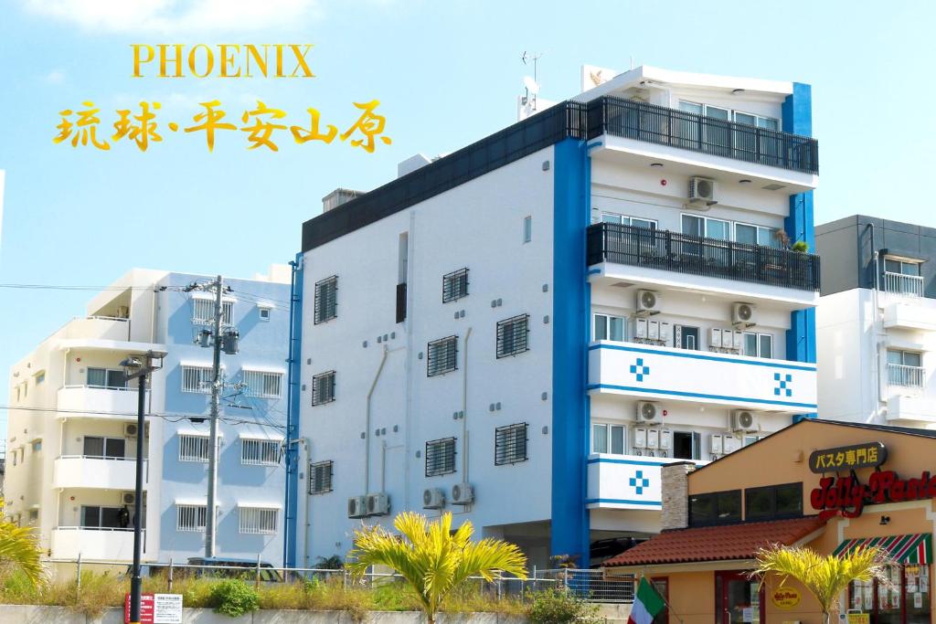 北谷町Phoenix Ryukyu Henzanbaru -SEVEN Hotels and Resorts-的蓝色修饰的白色建筑,毗邻建筑