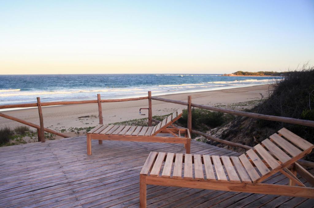 托弗海滩Musica do Mar Beach Front Apartments, Ocean View的海滩旁木板路上的2个长椅