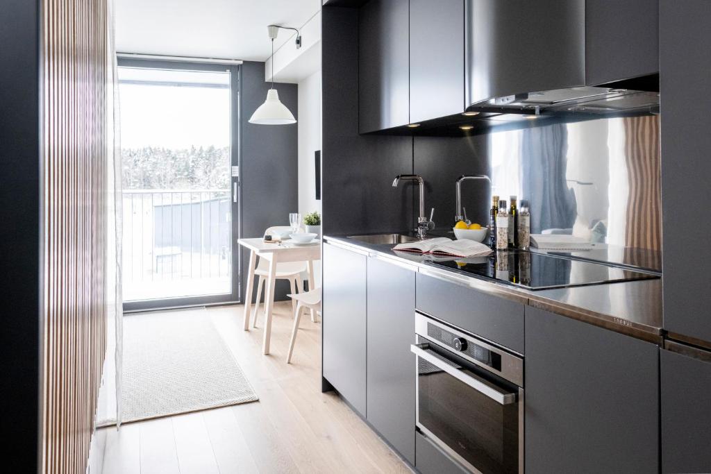 耶尔费拉HOOM Home & Hotel Järfälla的一间厨房,内设黑色橱柜和一张桌子