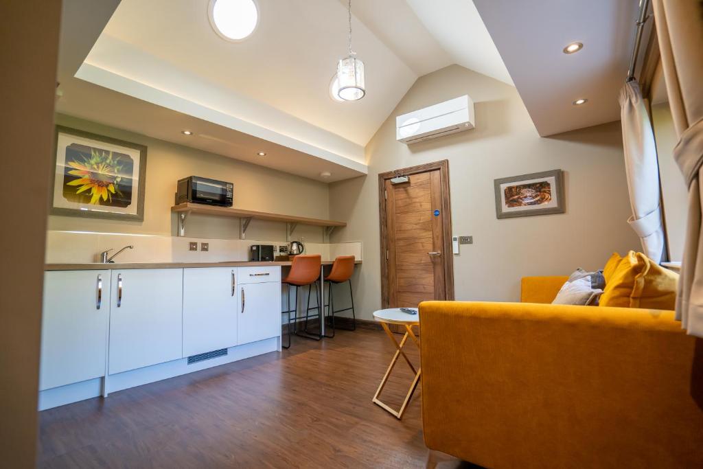伍尔弗汉普顿Bond Street Apartments的厨房以及带黄色沙发的客厅。