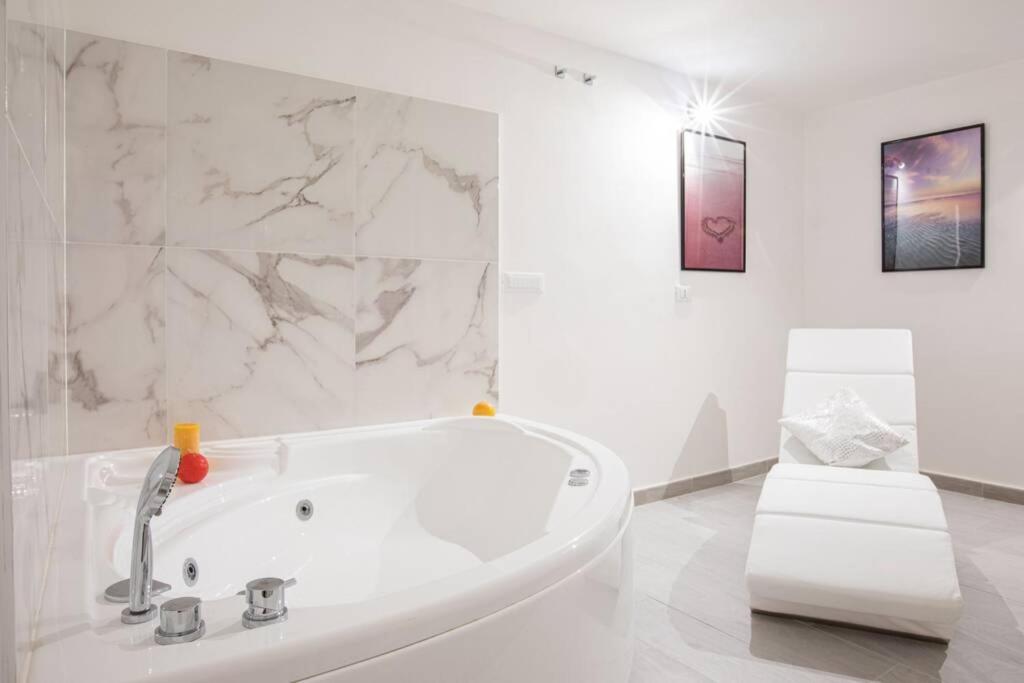 罗马Unforgettable Split Level Jacuzzi Suite Navona - Top Collection的白色浴室设有白色浴缸和大理石墙壁。
