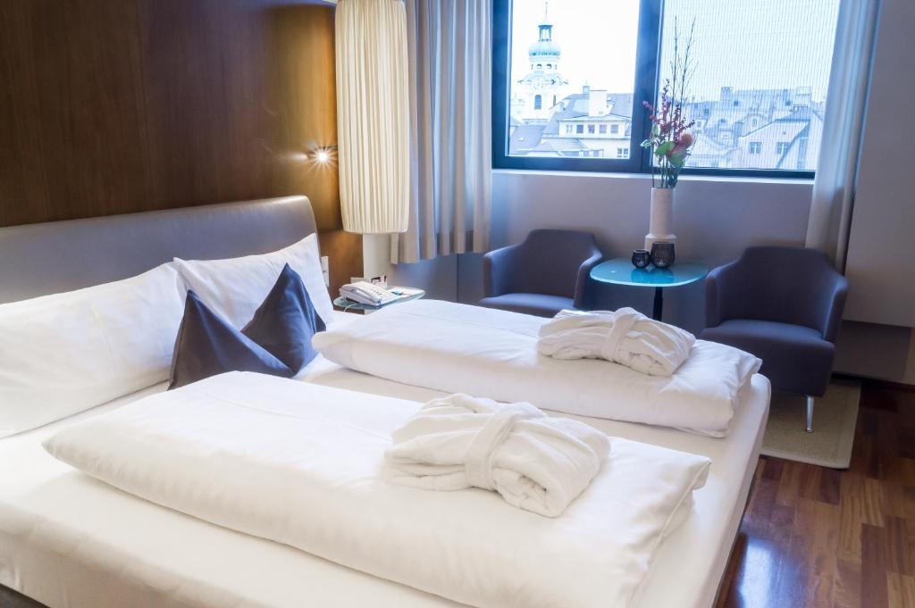 因斯布鲁克朋兹酒店的两张位于酒店客房的床,配有毛巾