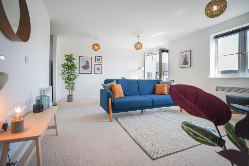 卡迪夫Stylish Apartment with Private Parking的客厅配有蓝色的沙发和桌子