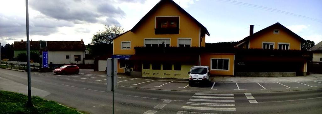 Našicerestoran i prenoćište Egghus的停在黄色房子前面的白色汽车