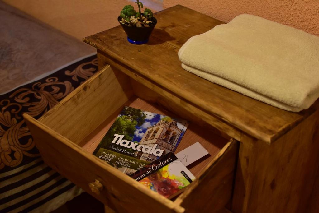 瓦曼特拉Hostal Quinto Sol Huamantla的桌子上带杂志的木盒