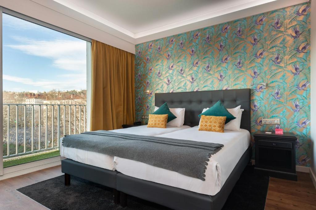 里昂Hôtel Charlemagne by Happyculture的一间卧室设有一张床和一个大窗户