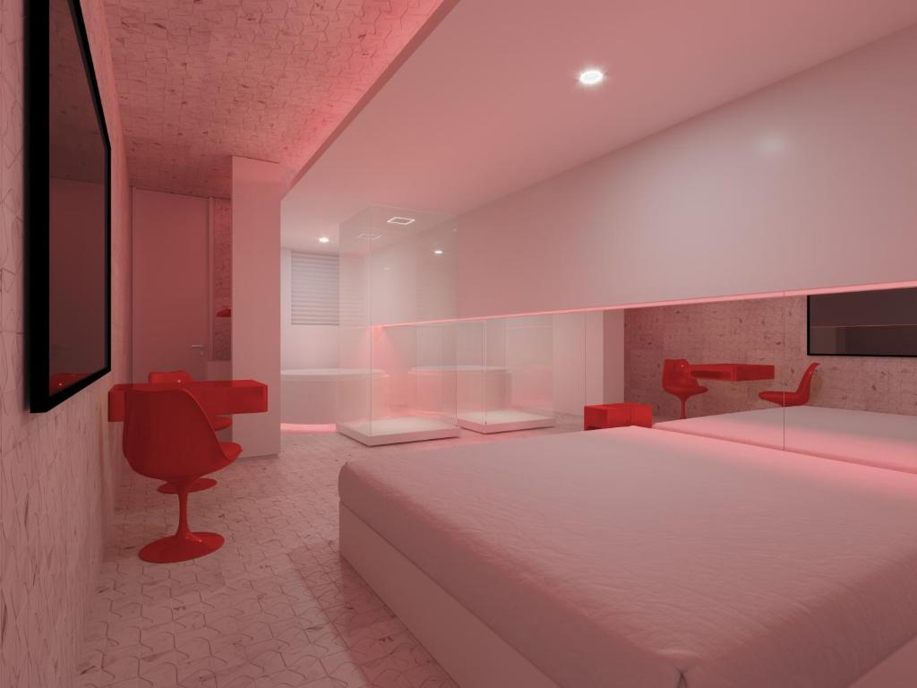 库里提巴Motel Você Que Sabe (Adult Only)的卧室配有白色的床和红色椅子