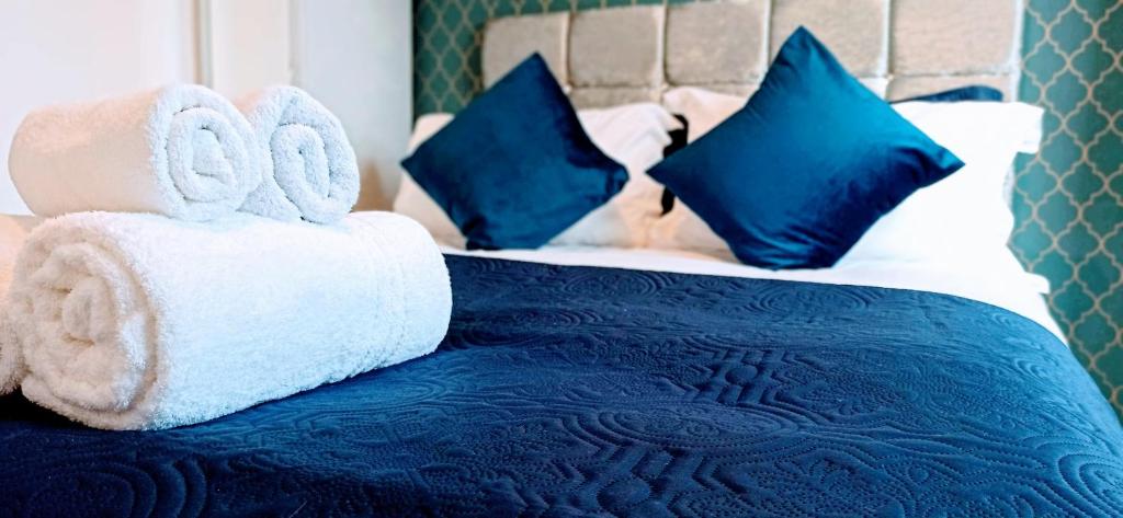 牛津Brookside 2BR Flat Oxford City Centre Free Parking的蓝色和白色的床,配有毛巾和枕头