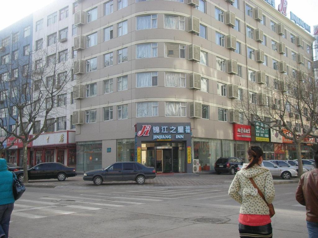 黄岛锦江之星青岛开发区香江路店的走在建筑物前的街道上的女人
