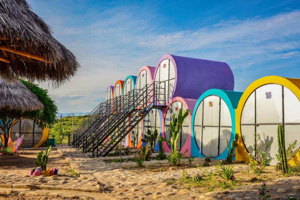 比利亚维哈Tubo Hotel La Tatacoa的海滩上一座拥有色彩缤纷的门和楼梯的建筑