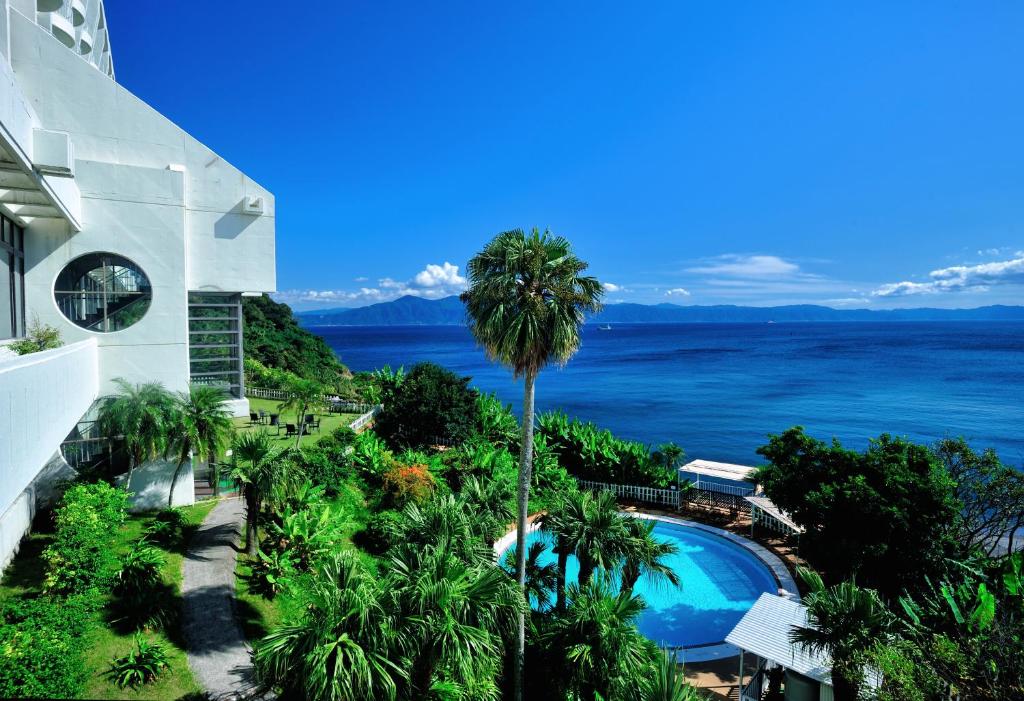指宿市指宿皇家酒店的棕榈树和游泳池的建筑享有海景