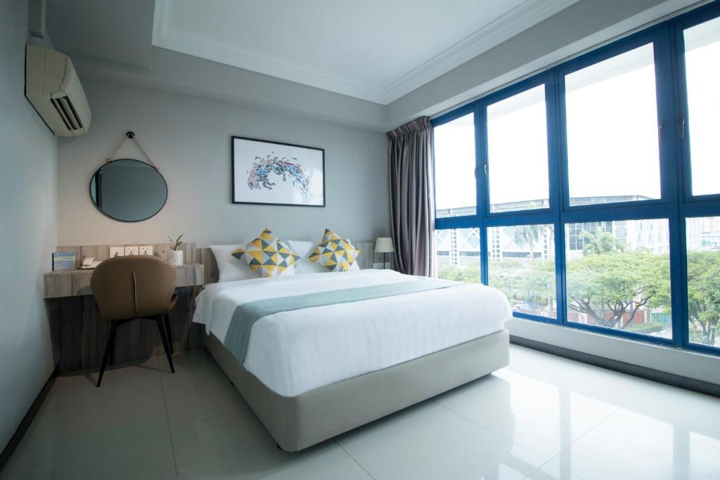 新加坡Harbour Ville Hotel的卧室配有一张床、一张书桌和窗户。