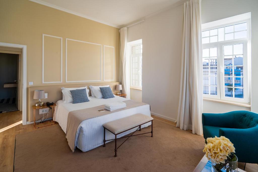 普拉亚达巴拉灯塔酒店的卧室配有白色的床和蓝色椅子