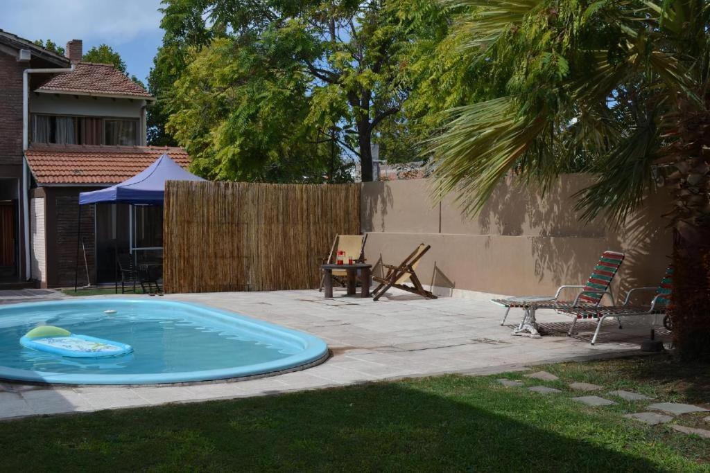 门多萨Open House Hostel的一个带桌子和围栏的庭院内的游泳池