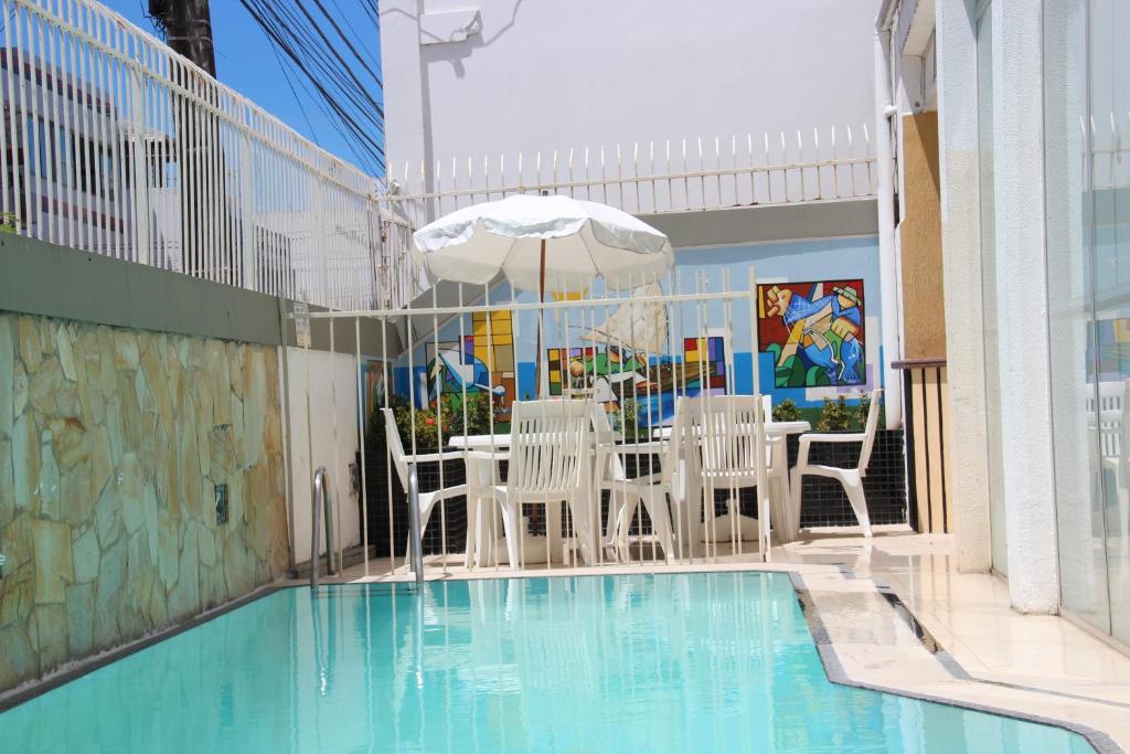 阿拉卡茹简加德罗酒店的池畔露台配有桌椅