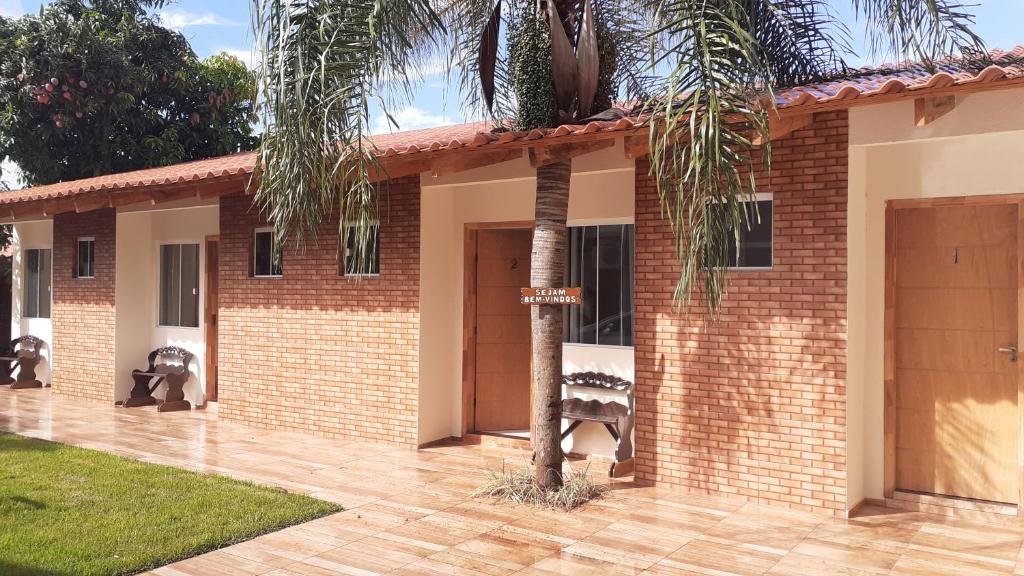 伊瓜苏Pousada recantoceccataratas的前面有棕榈树的砖房
