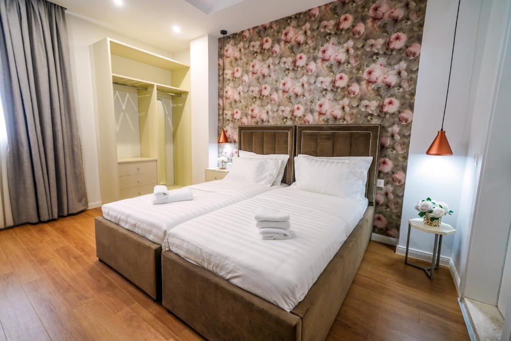 地拉那Rama's Hotel的一间卧室设有一张带花卉墙壁的大床