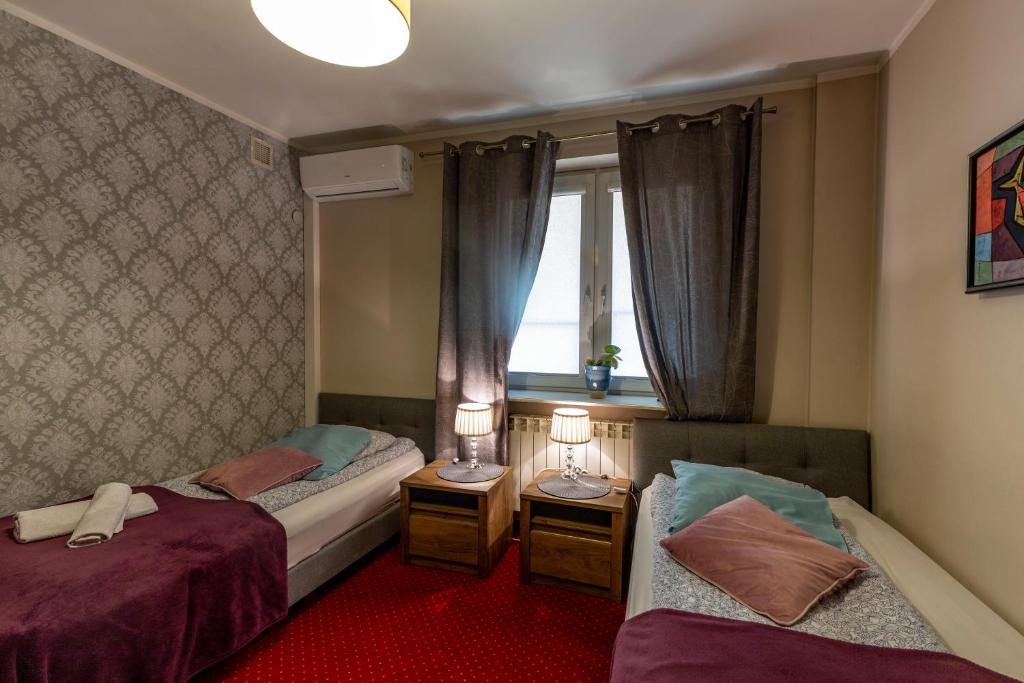 华沙卡瓦别墅酒店的一间卧室设有两张床和窗户。