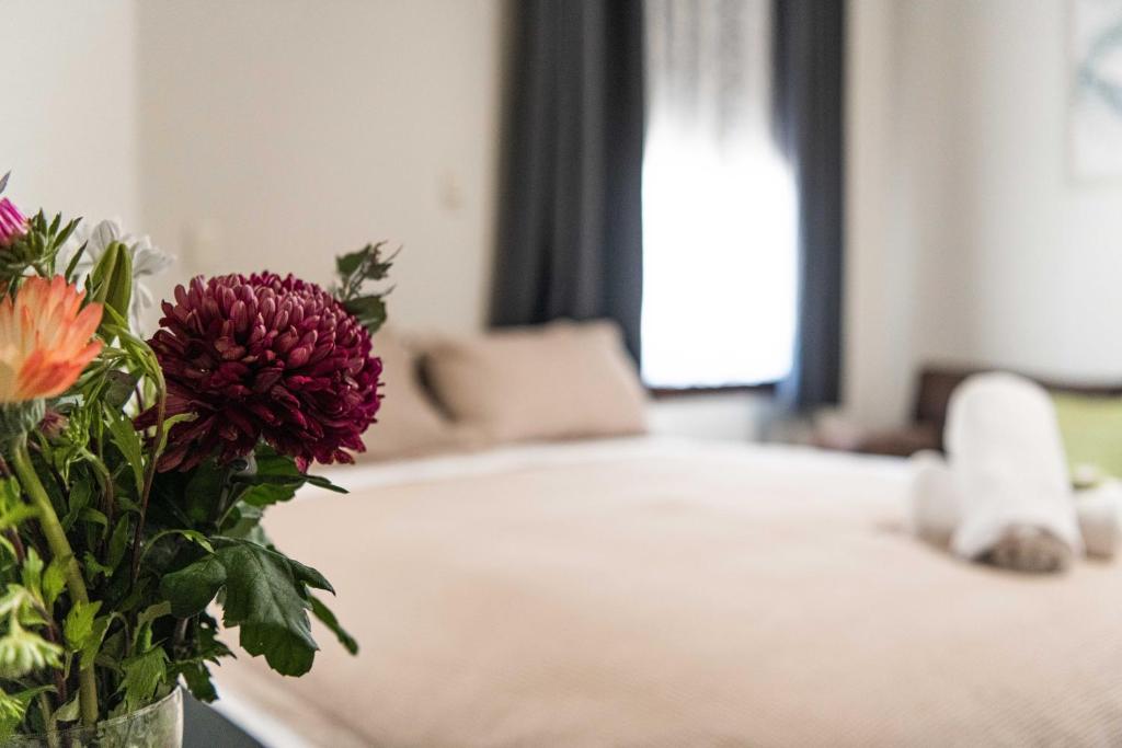 海伊New Crown Hotel Motel的卧室里一个花瓶,桌子上放着鲜花
