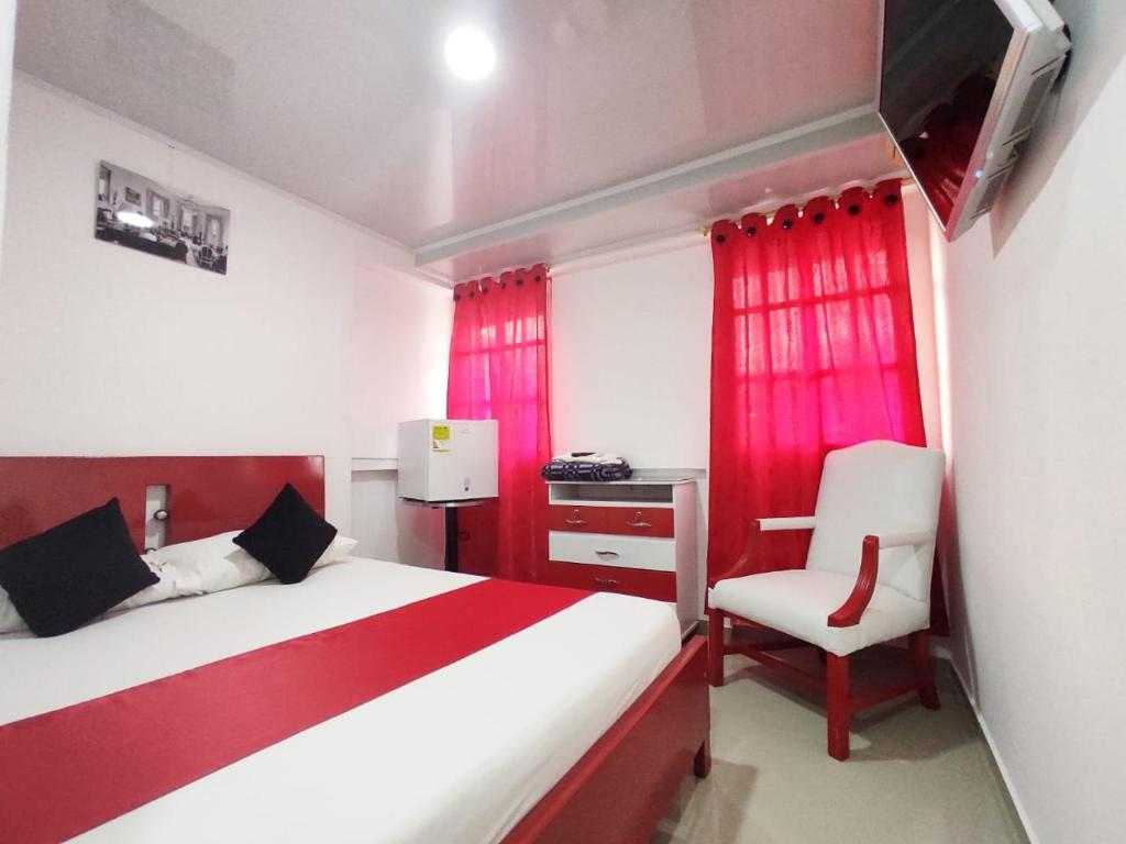 佛罗里达布兰卡Hotel Casablanca Cañaveral的卧室配有红色和白色的床和椅子