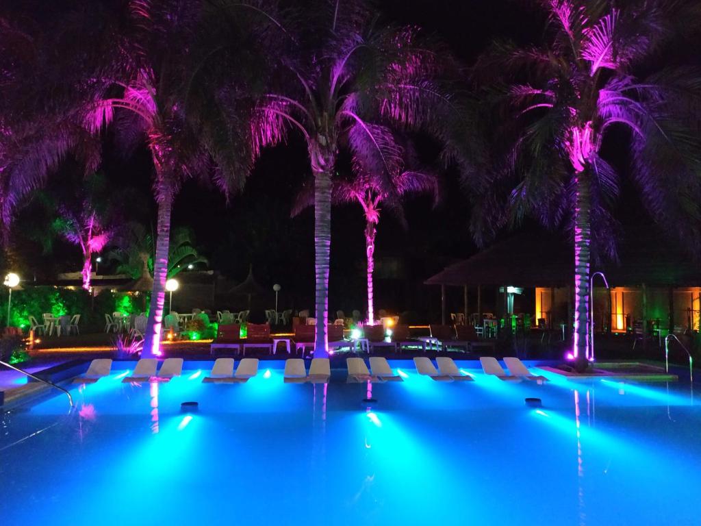 特尔马斯德里奥翁多Hotel Termal Emperatriz的游泳池在晚上设有椅子和棕榈树