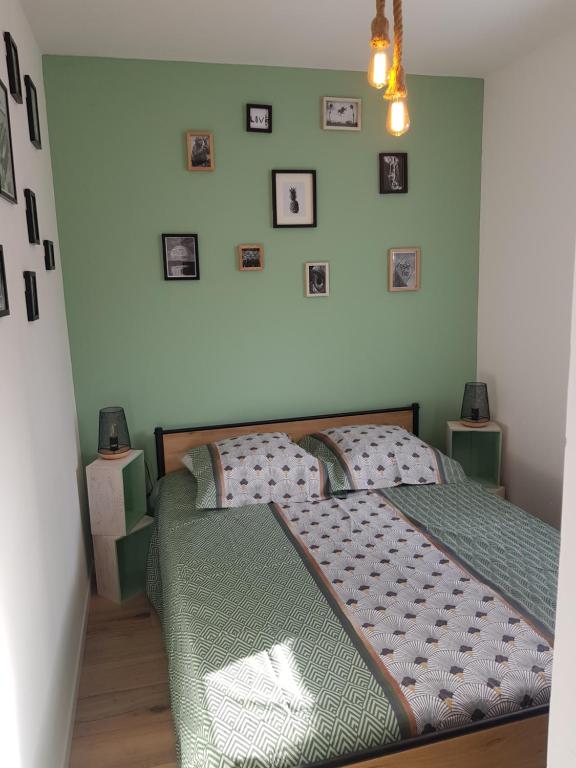 滨海埃尔芒维尔Normandie Sword Beach的卧室配有一张床,墙上挂有图片