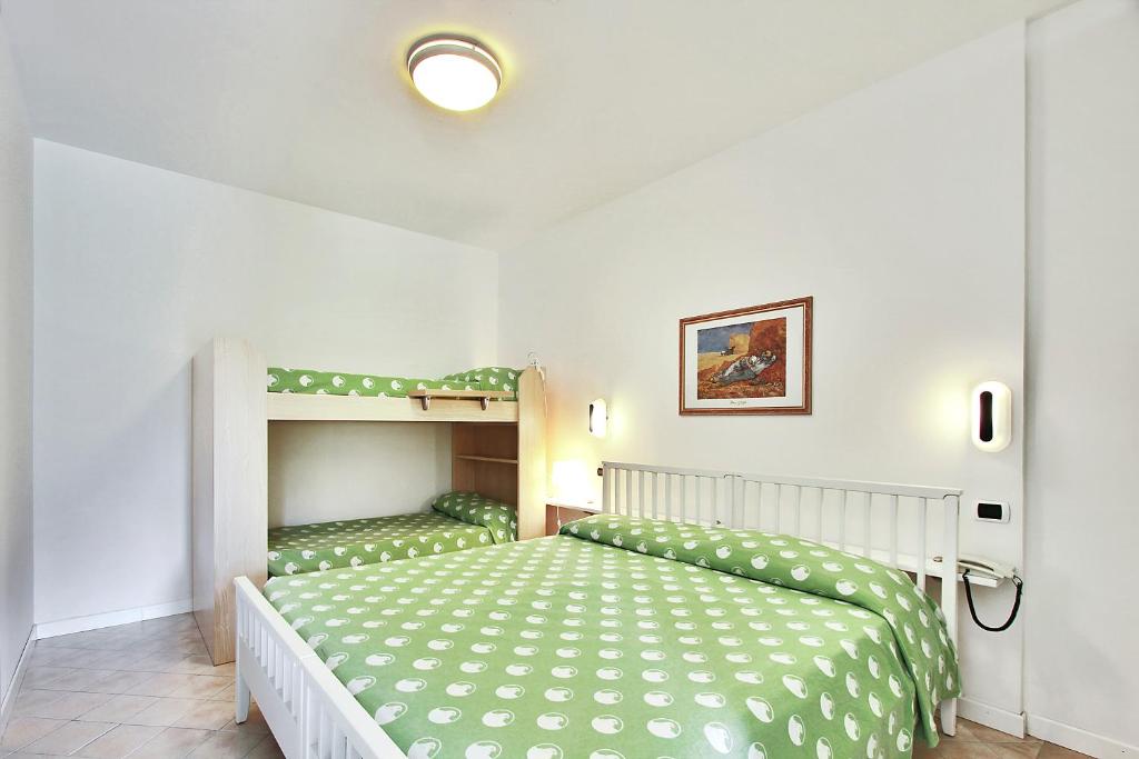 利尼亚诺萨比亚多罗蓬扎公寓式酒店的一间卧室配有一张床和一张双层床。
