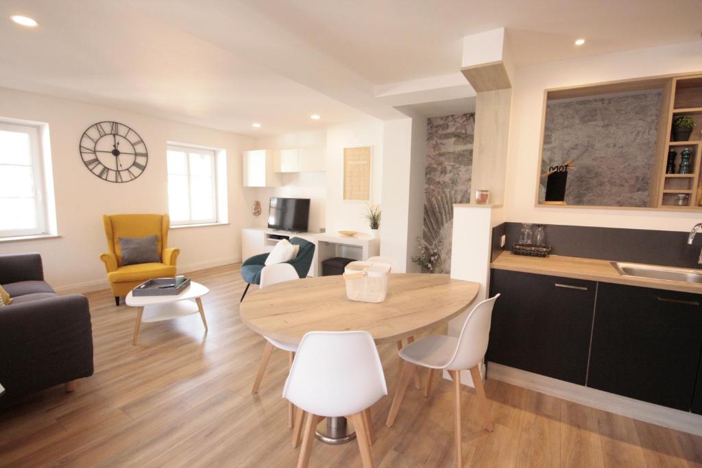 阿梅尔斯克维Appartement L'Oriel avec Parking的厨房以及带桌椅的起居室。