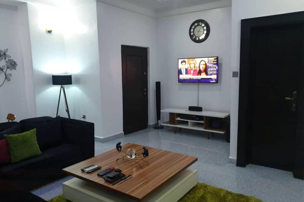 阿布贾Well furnished and spacious 2 bedroom apartment的带沙发、桌子和电视的客厅