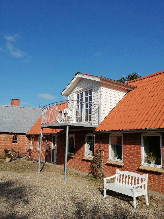 ErslevStenhøj Bed and Breakfast, v. Jette og Marius的一座带篮球架的橙色屋顶的房子