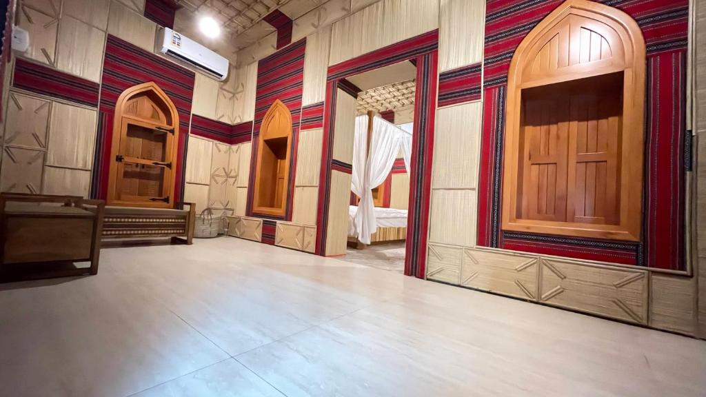 马斯喀特Fort Guesthouse نُزل القلعة的一间空房间,有木门,还有一间房间,有一张床