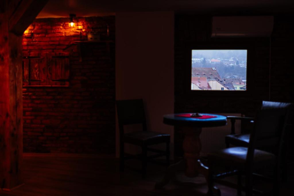 锡吉什瓦拉Casa Moldo的一间设有桌椅和电视的黑暗客房。