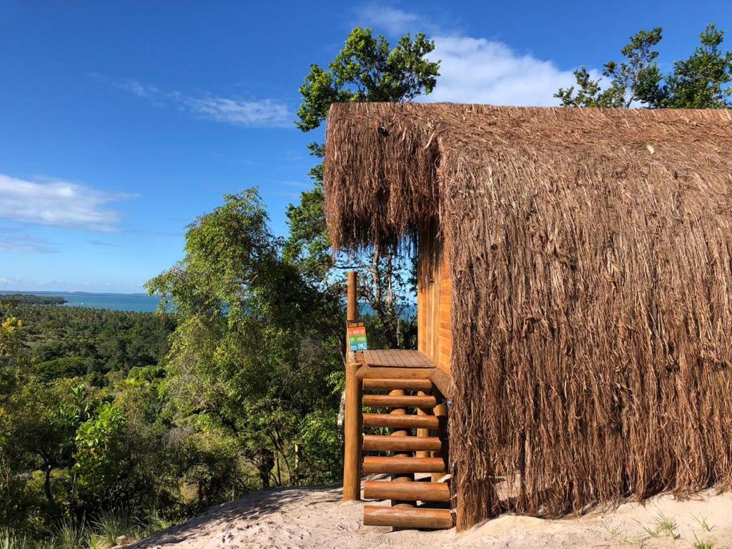 莫雷雷Nature Moreré - Bangalôs com vista para o Mar的小屋设有茅草屋顶和楼梯