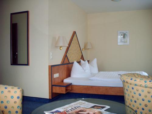 奥尔登堡亚历山大酒店的卧室配有1张床、1张桌子和1把椅子