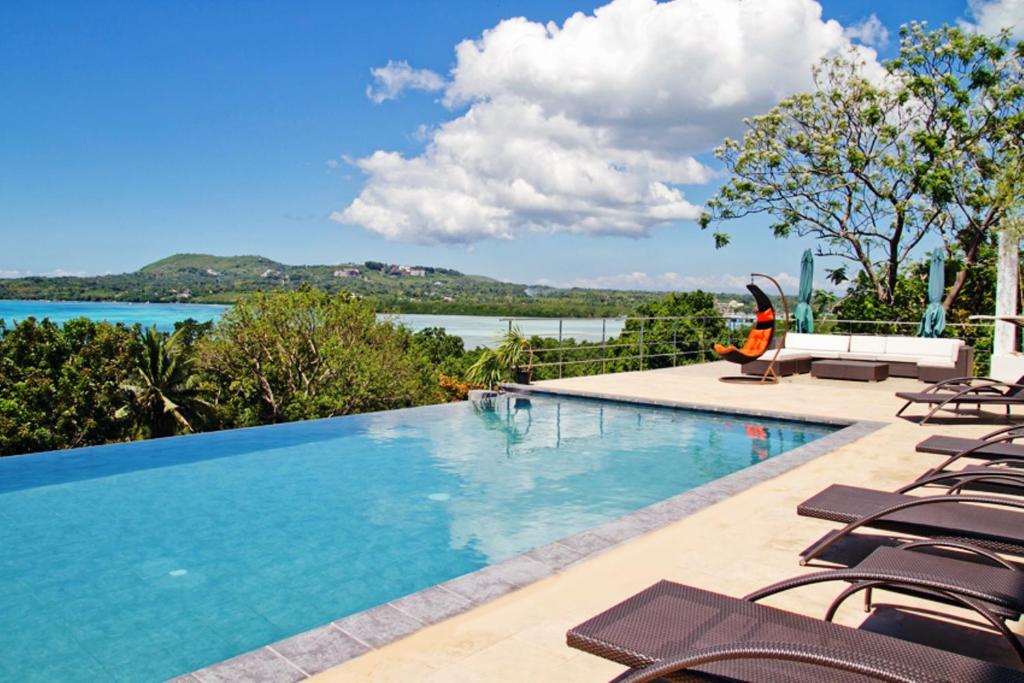 塔比拉兰保和海景套房精品酒店的一个带椅子的游泳池,享有水景