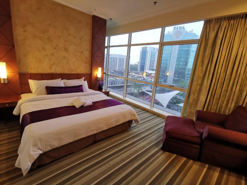 古晋StayInn Gateway Hotel Apartment的酒店客房设有两张床和大窗户。