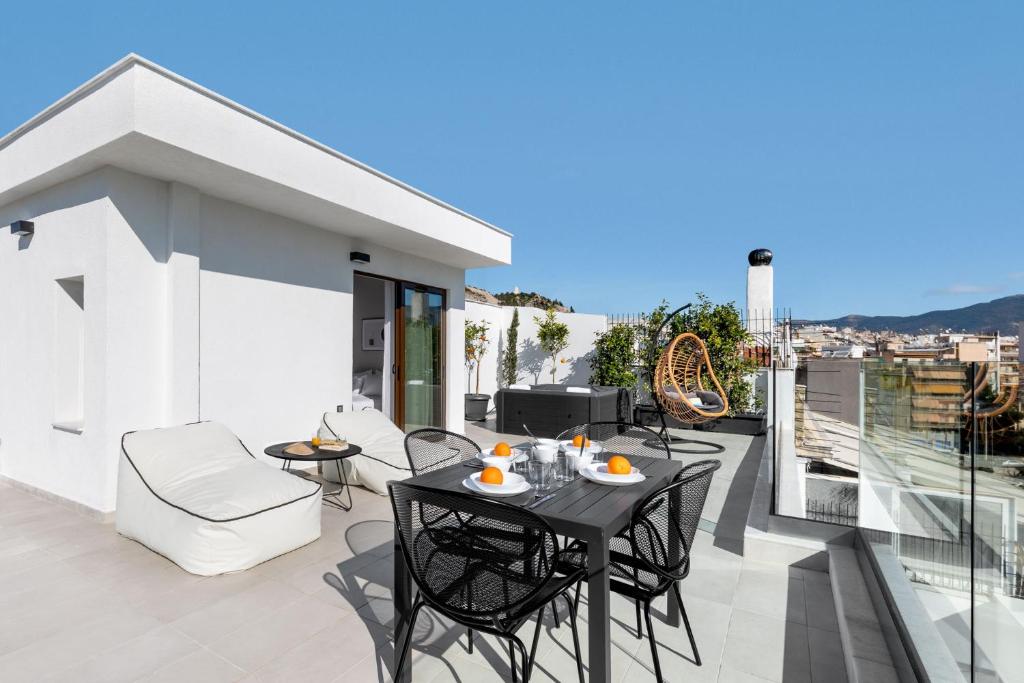 雅典Filopappou Hill Suites by Athens Stay的阳台的天井配有桌椅