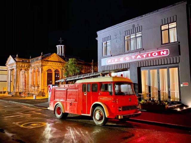 霍基蒂卡Hokitika Fire Station Boutique Accommodation的停在大楼前的一辆旧红色卡车