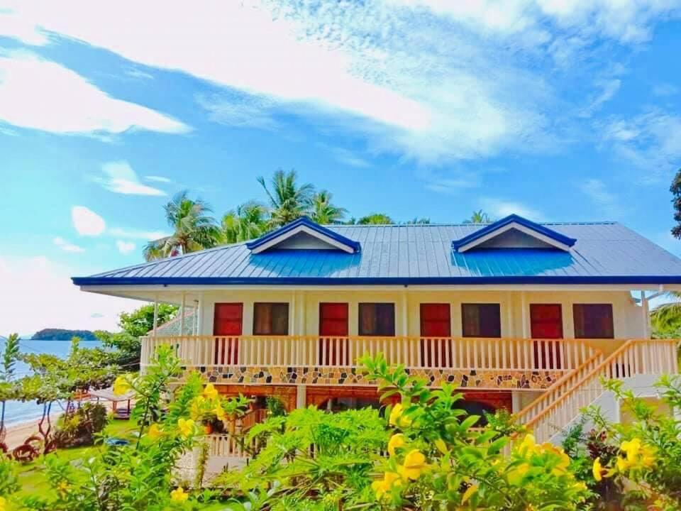 RomblonKaburihan Beach Resort的一座有红色门和蓝色屋顶的房子