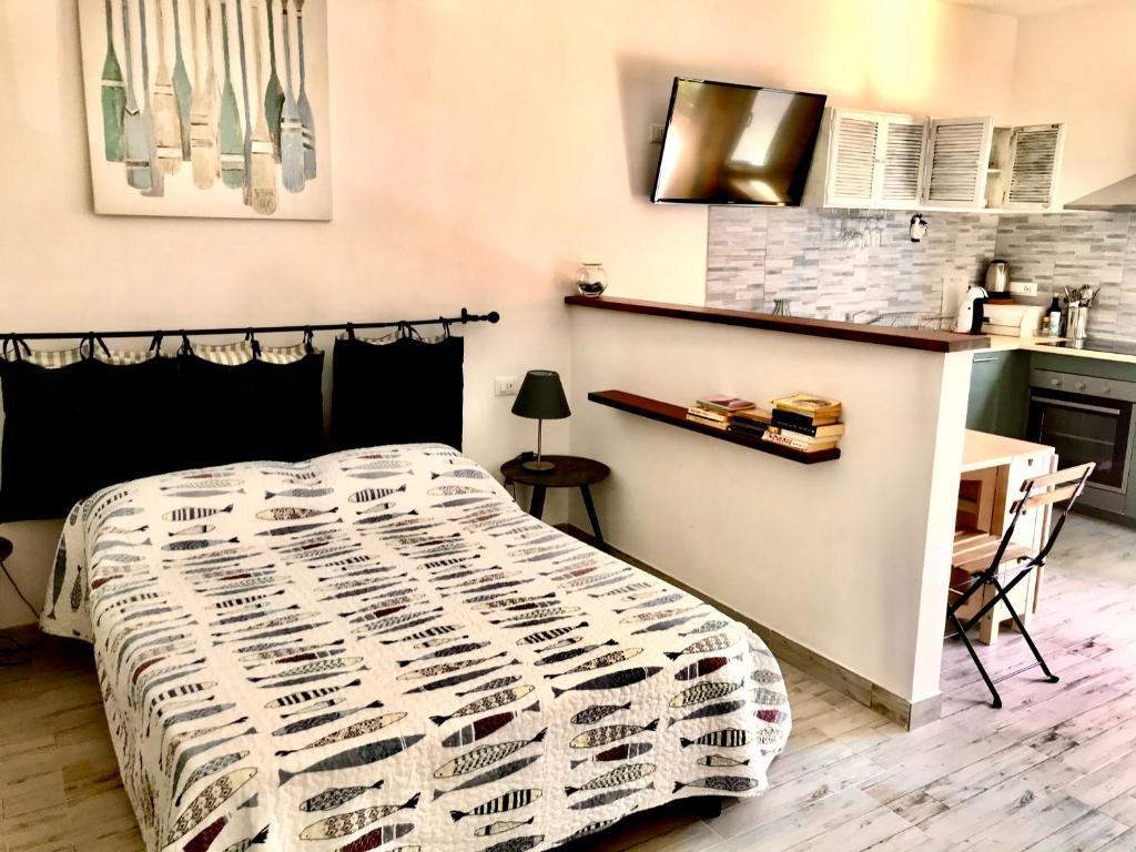 蒙特罗索阿尔马雷Cà Lea,2 Minuti dalla Spiaggia di Monterosso的一间带一张床和一张书桌的卧室和一间厨房