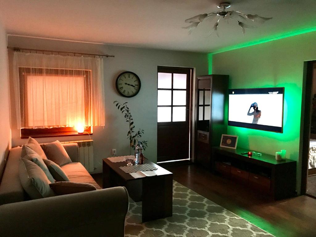斯克拉斯卡波伦巴Gór-SKI Apartament的客厅配有沙发和带绿灯的电视。