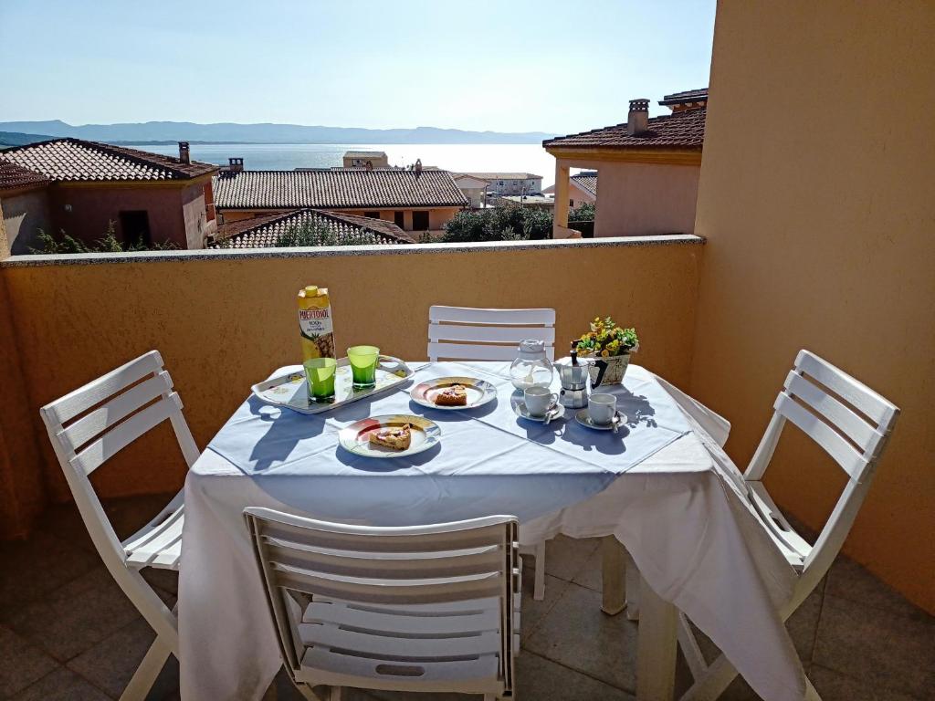 罗萨岛Tanca della Torre Trilocale vista mare的阳台上摆放着食物盘的桌子