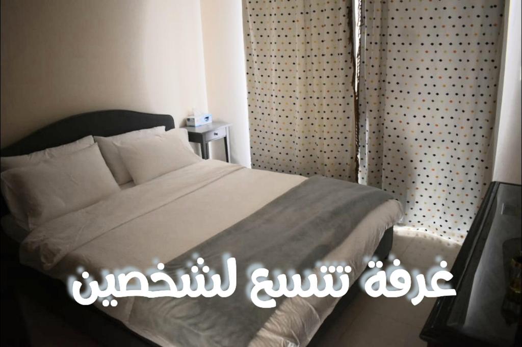 拉斯阿尔卡麦قرية الحمرا راس الخيمة的一间卧室,配有一张带标志的床