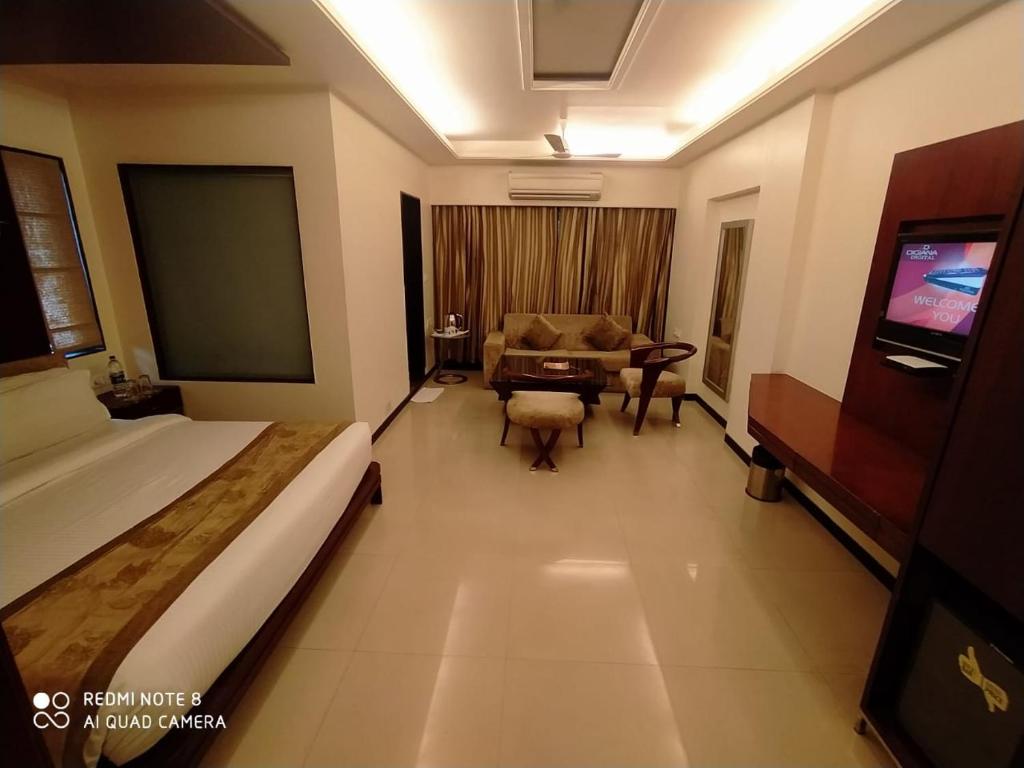 印多尔Kyriad Hotel Indore by OTHPL的酒店客房配有床、沙发和桌子。