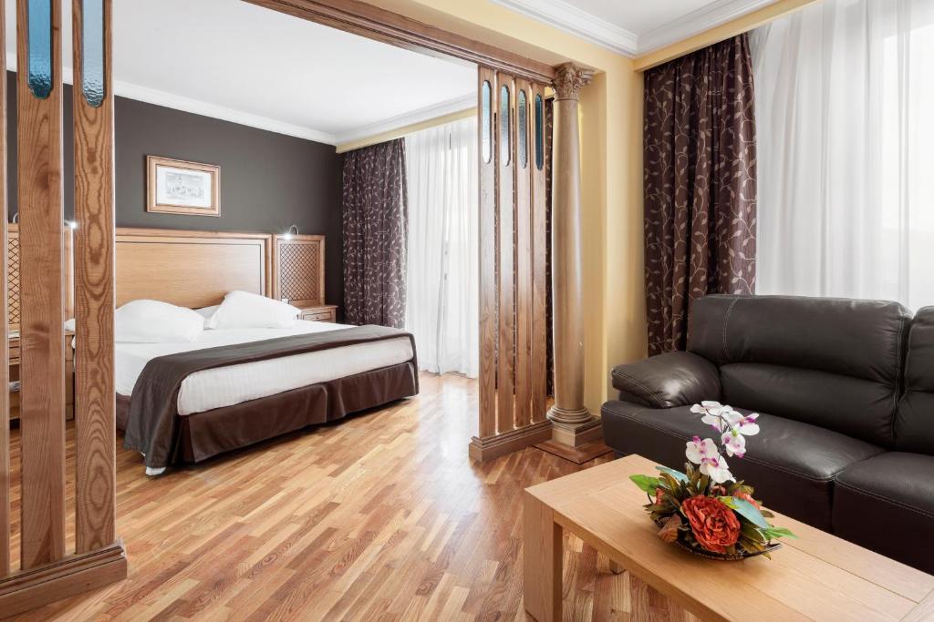 雷阿尔城Exe Doña Carlota的酒店客房,配有床和沙发