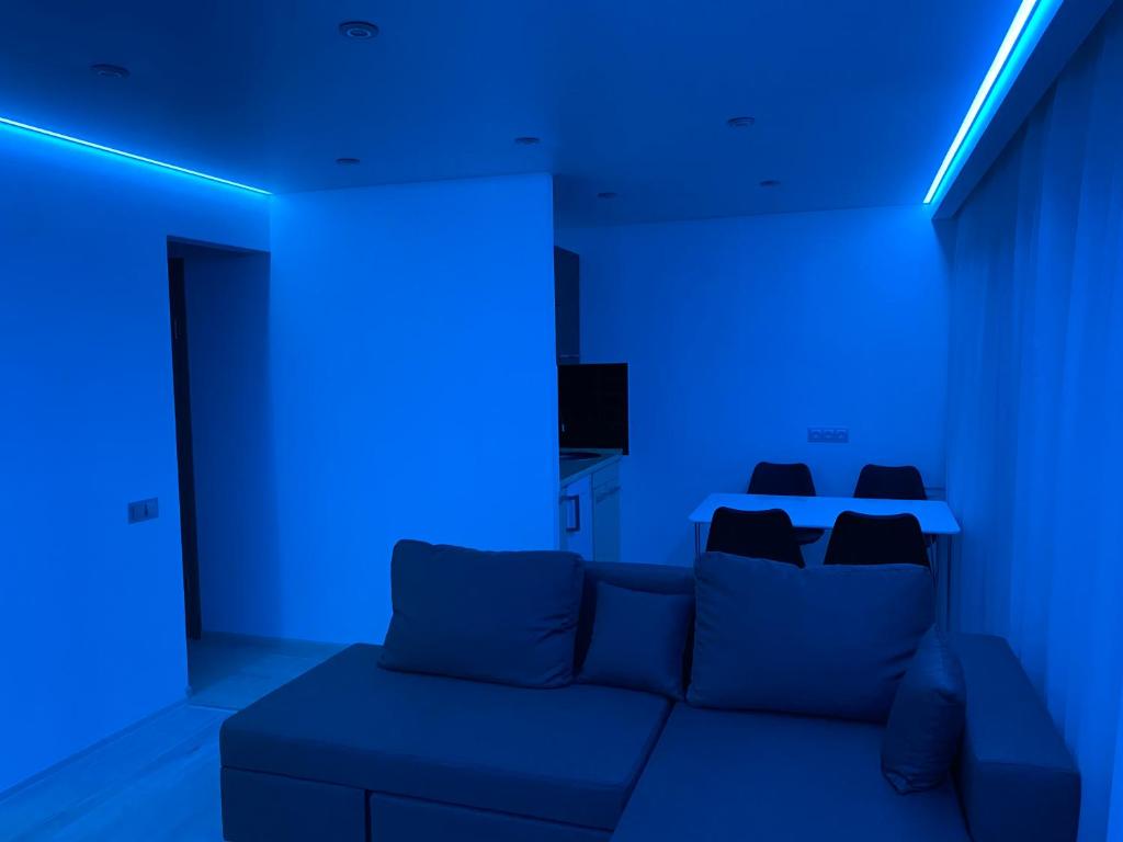 第聂伯罗Апартаменты Бульвар Славы 21的蓝色的客房设有沙发和蓝色的灯光