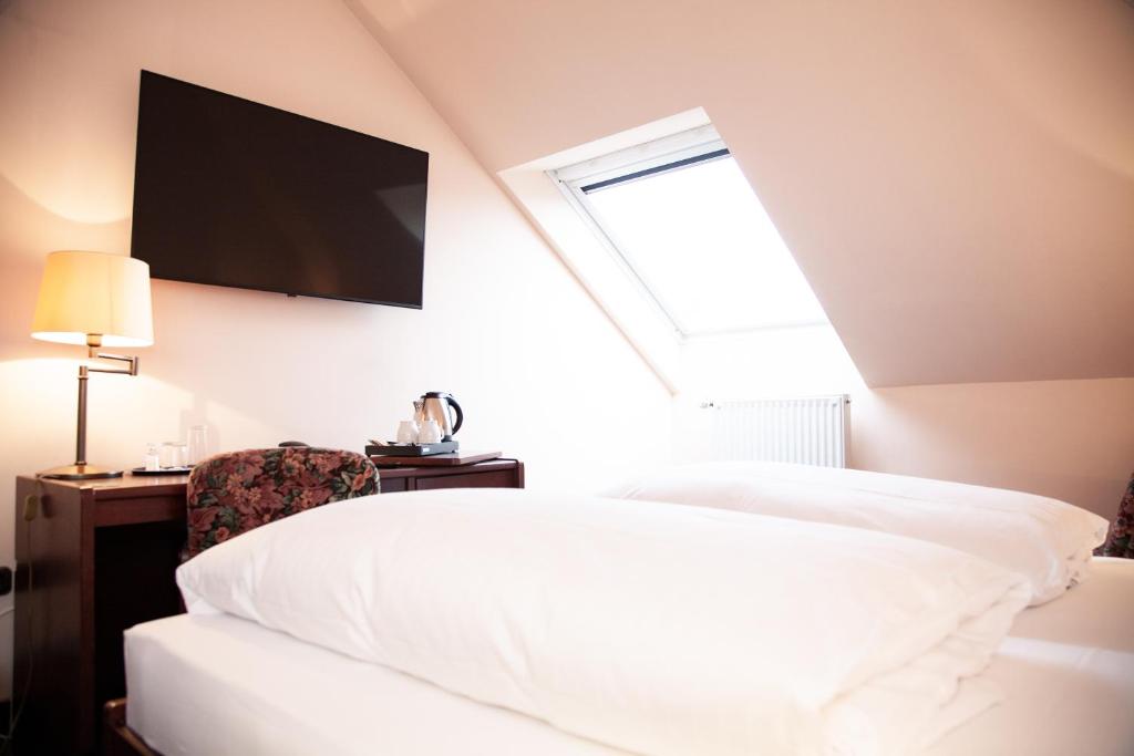 杜伊斯堡隆纳克酒店的卧室配有一张床,墙上配有电视。