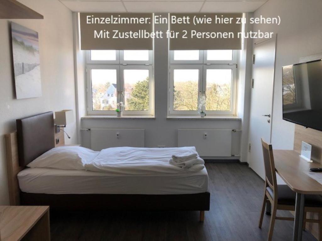 不来梅港BusinessInn.de Aparthotel Bremerhaven的一间卧室设有一张床和两个窗户。