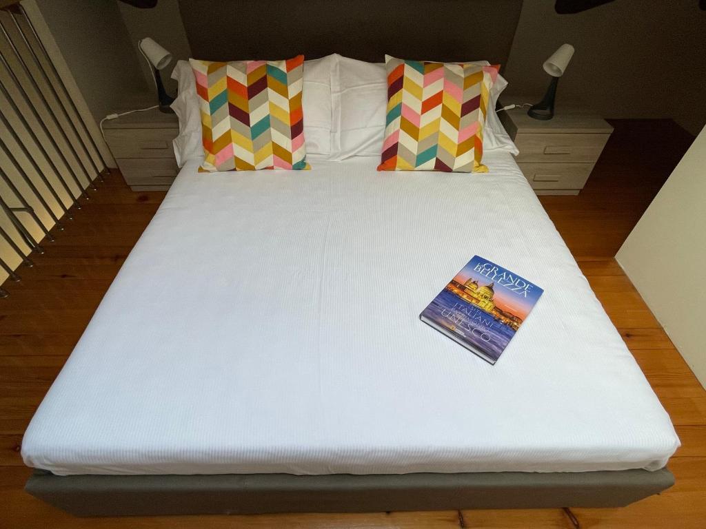 凯拉斯科conGusto Apartments的一张白色大床,上面有书